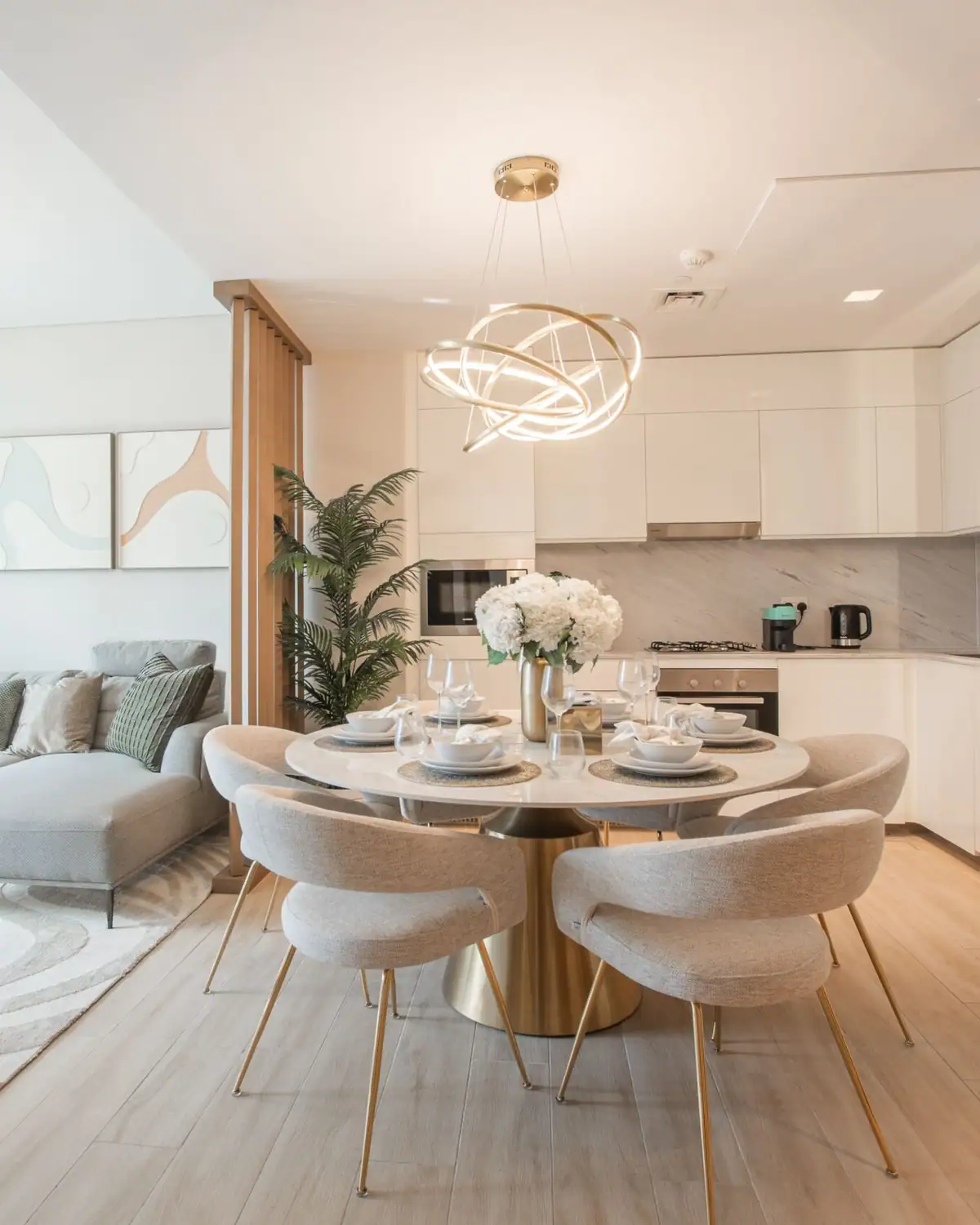 Representative image of a bright dining and living area with a marble table and gold accents
